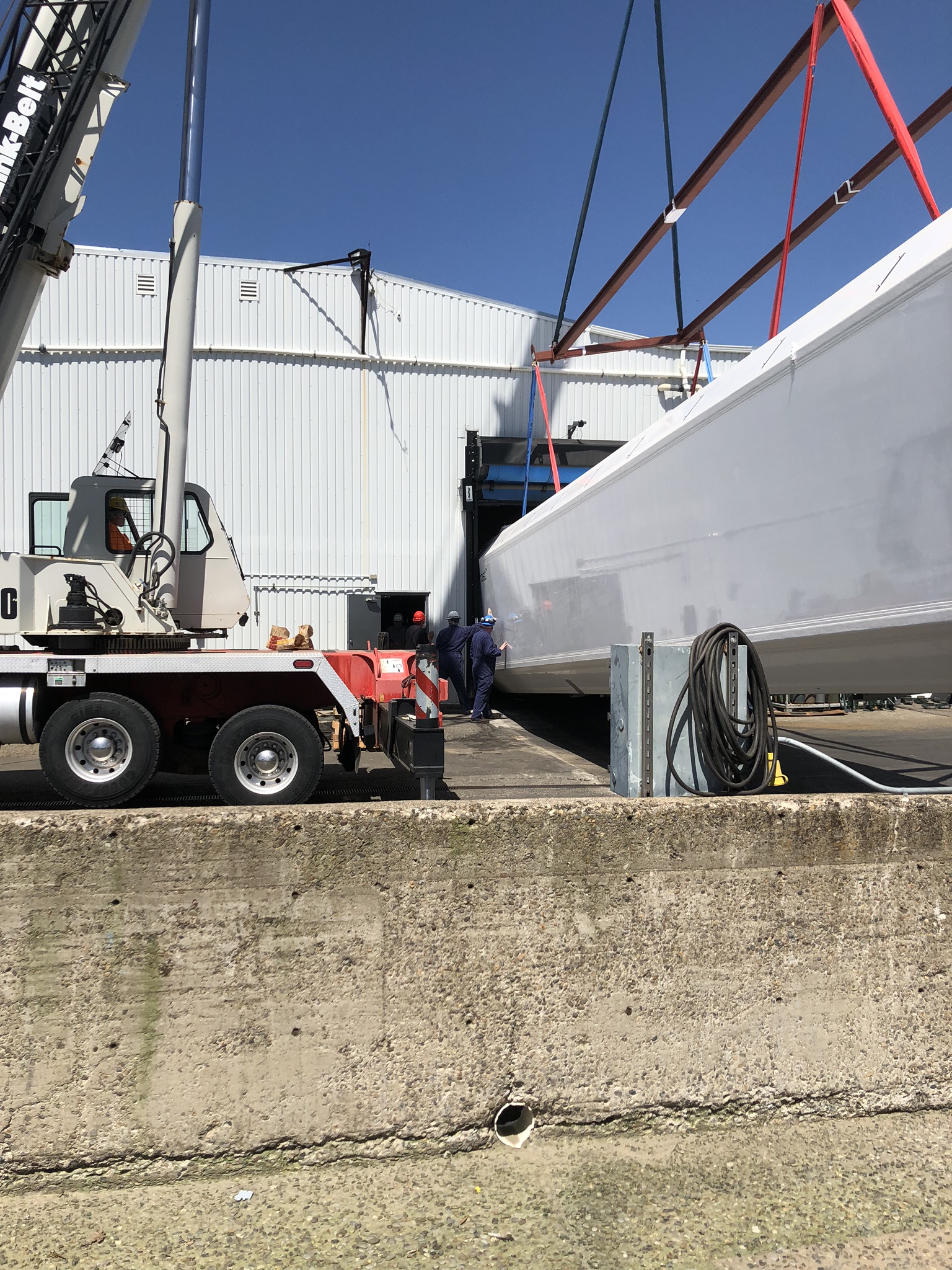 Crane lifting a freezer into a facility